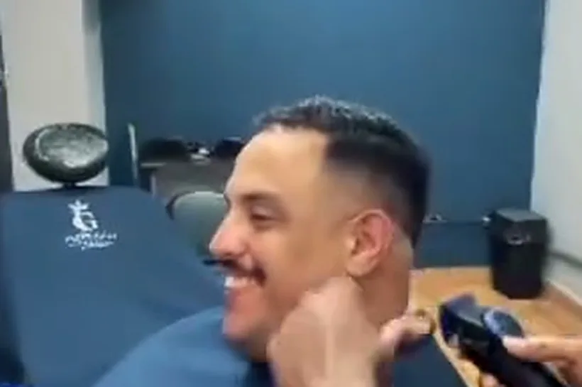Cliente sorrindo na cadeira da Império Garcia durante o acabamento do degradê